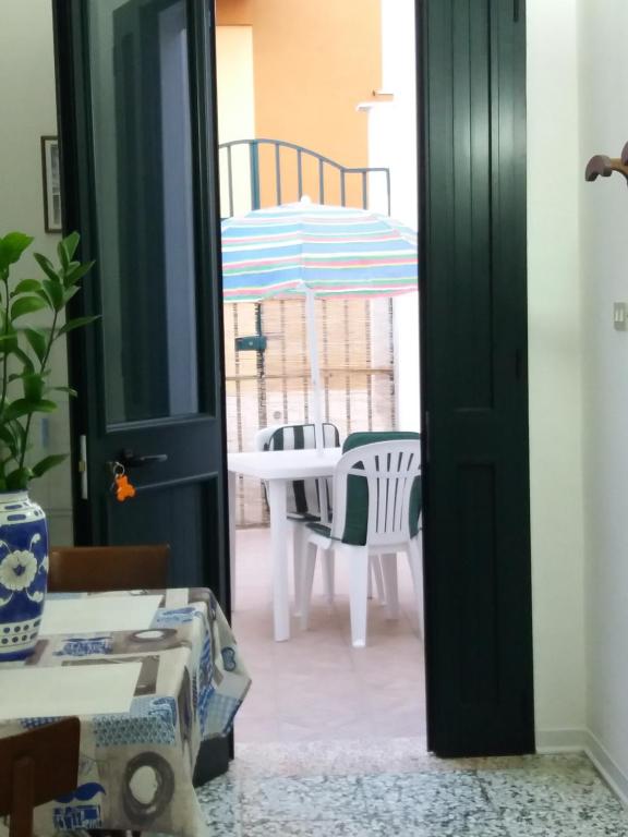 een open deur naar een patio met een tafel en een parasol bij Casa vacanze Annette in Santa Maria al Bagno