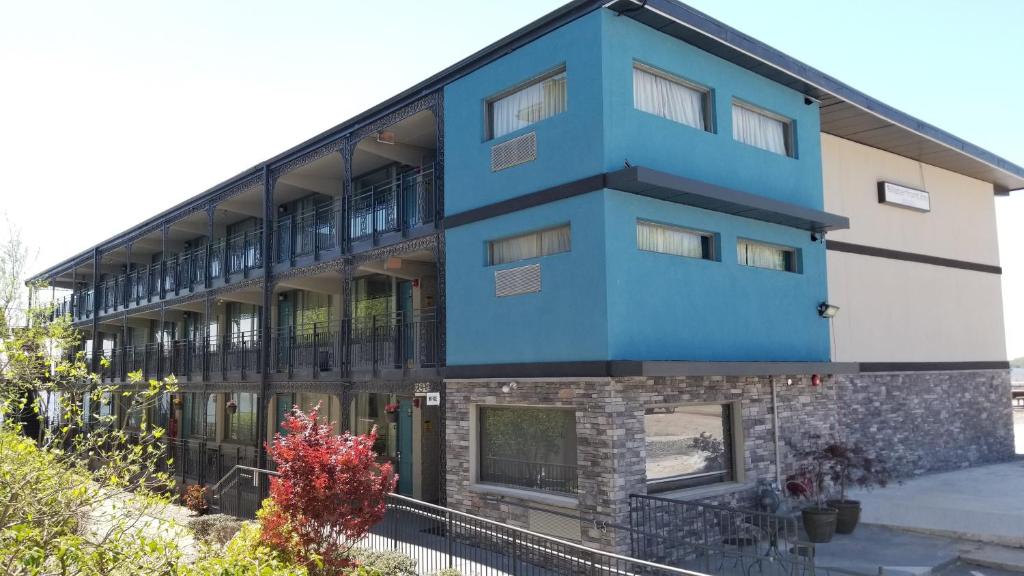 a blue and white building with plants in front of it at Airport Waterfront Inn in Essington