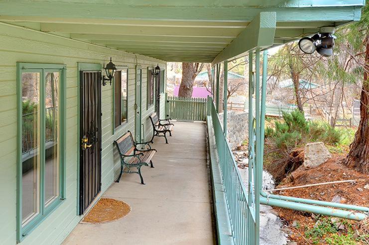 a porch of a green house with benches on it at Ramsey Canyon B&B Apartment Suites in Nicksville