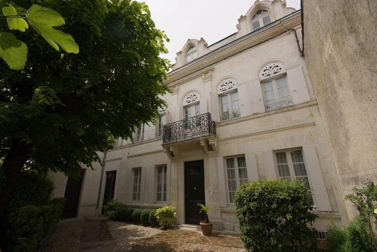 un gran edificio blanco con balcón. en Chambres d'Hôtes Les Tilleuls, en Cognac