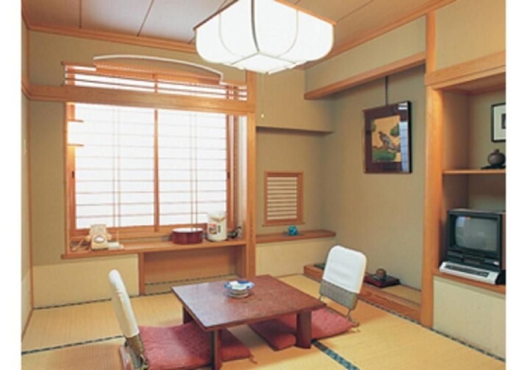 Wakaba Ryokan / Vacation STAY 29375 في ساكاتا: غرفة معيشة مع طاولة وتلفزيون