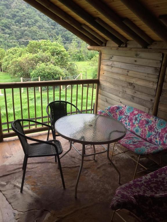 a patio with a table and chairs on a porch at Palmas de Cocora in Salento