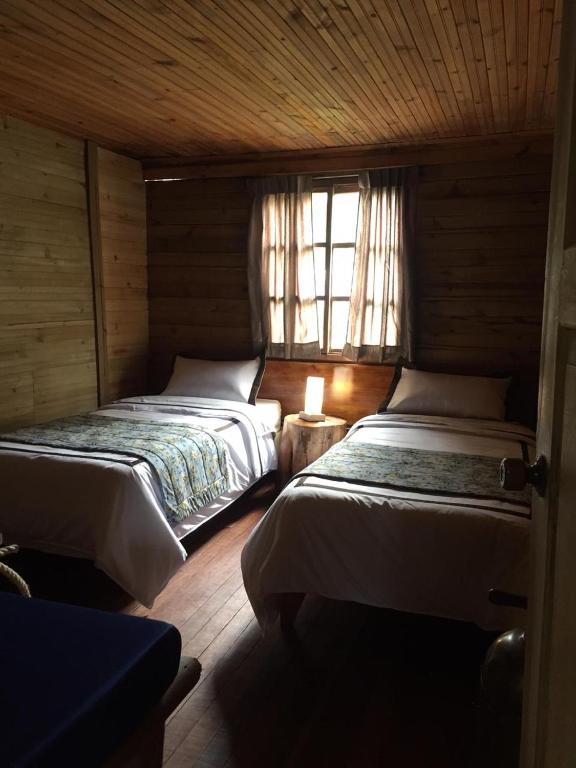a bedroom with two beds and a window at Palmas de Cocora in Salento