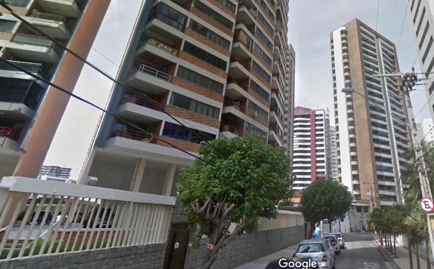 une rue de la ville avec de grands bâtiments et une voiture dans l'établissement Apto-beiramar-completo-3 qt- até 9 pes-TV-WiFi-gar, à Fortaleza