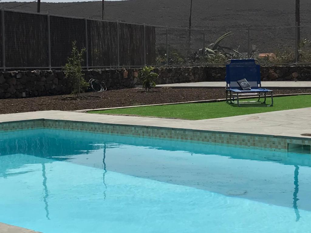 una silla azul sentada junto a una piscina en Casa de Los Alberconcillos, en Agüimes