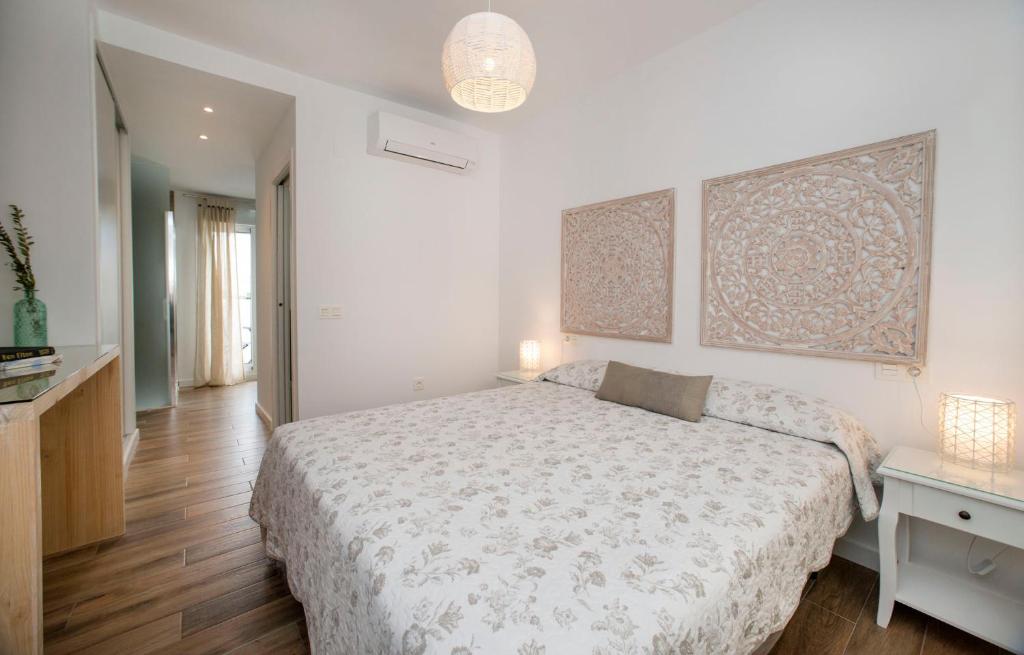 ein weißes Schlafzimmer mit einem Bett und einem Tisch in der Unterkunft La Casita del Atlántico in El Rompido