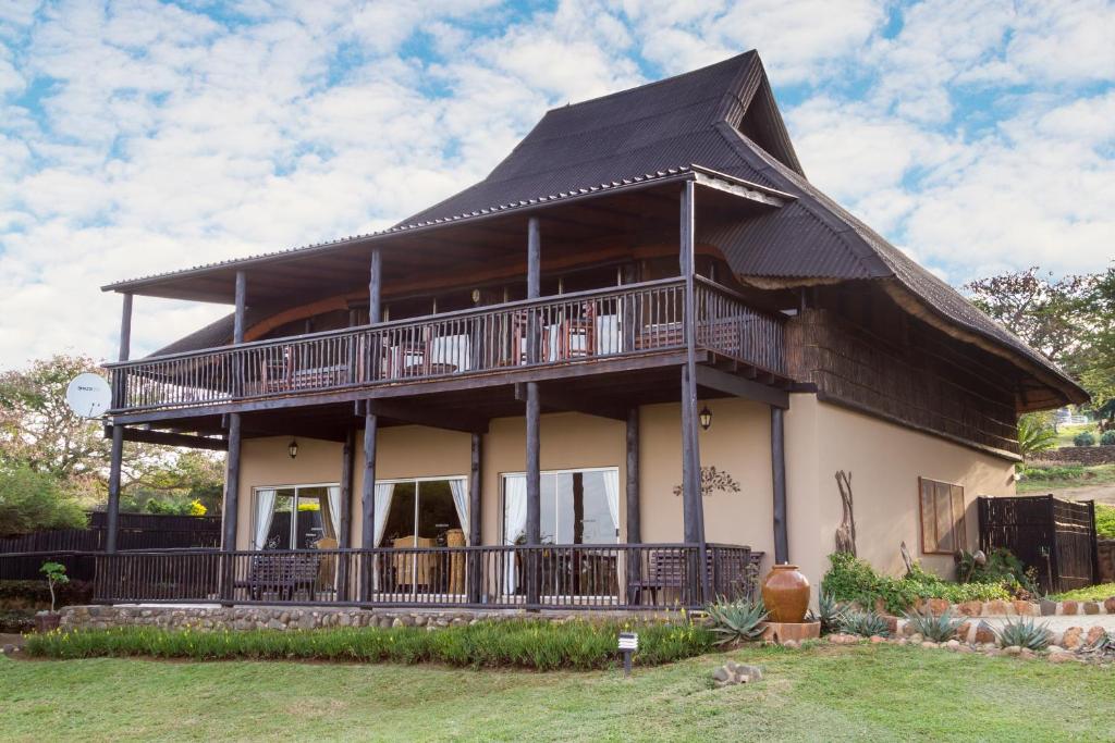 une grande maison avec un toit en gambrel dans l'établissement African Spirit Game Lodge, à Manyoni Private Game Reserve