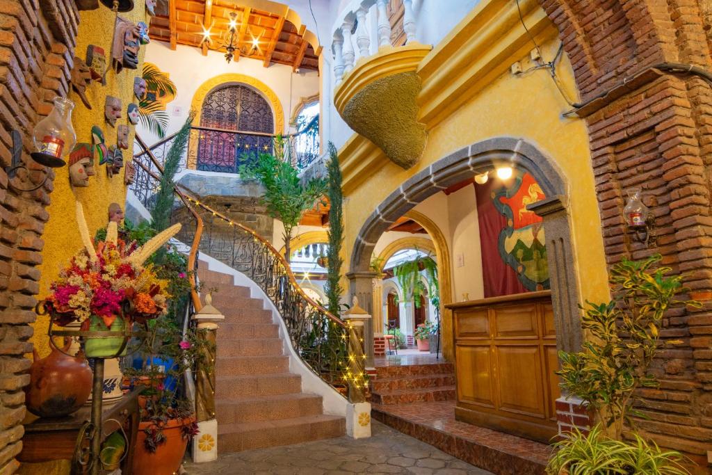 a staircase in a building with flowers and plants at Hotel Gran Plaza Euromaya in Antigua Guatemala