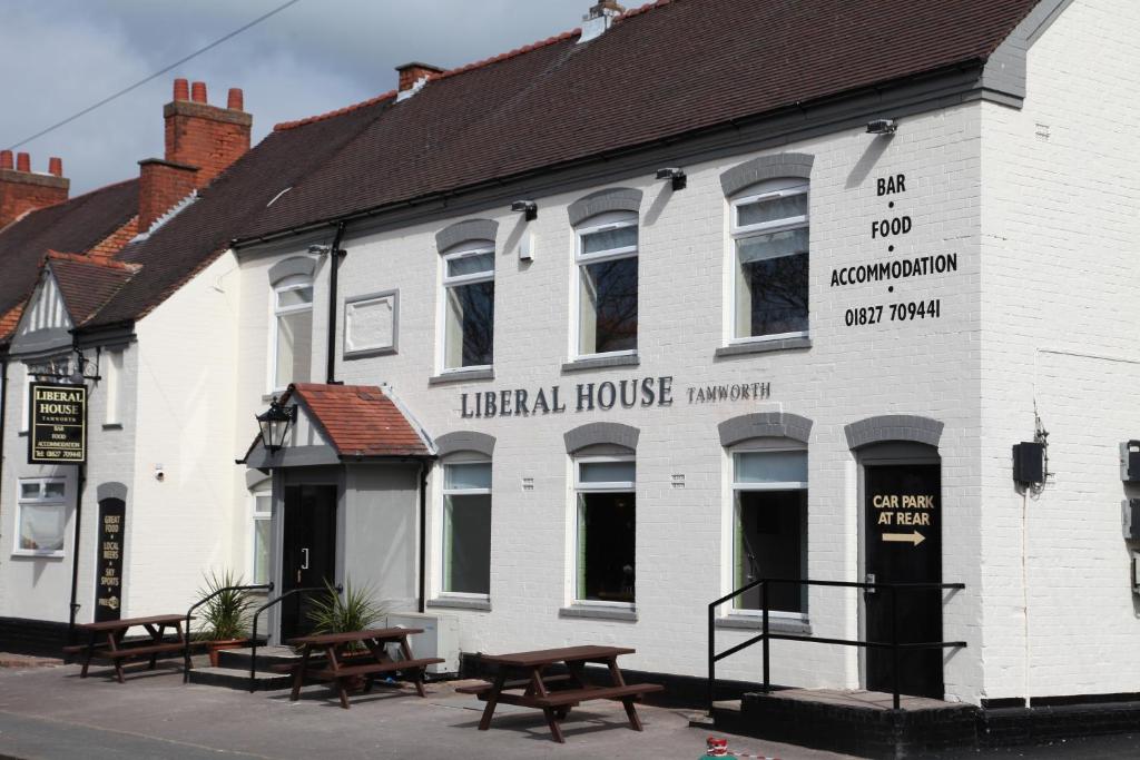 a white building with benches in front of it at Liberal House Tamworth in Tamworth