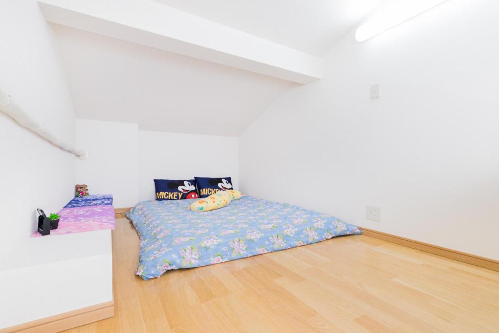 1 dormitorio con 1 cama en una habitación blanca en Haneda Airport Apartment en Tokio
