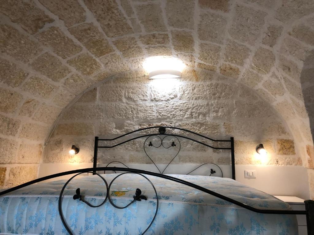 een bed in een kamer met een stenen plafond bij casa principe di napoli in Polignano a Mare