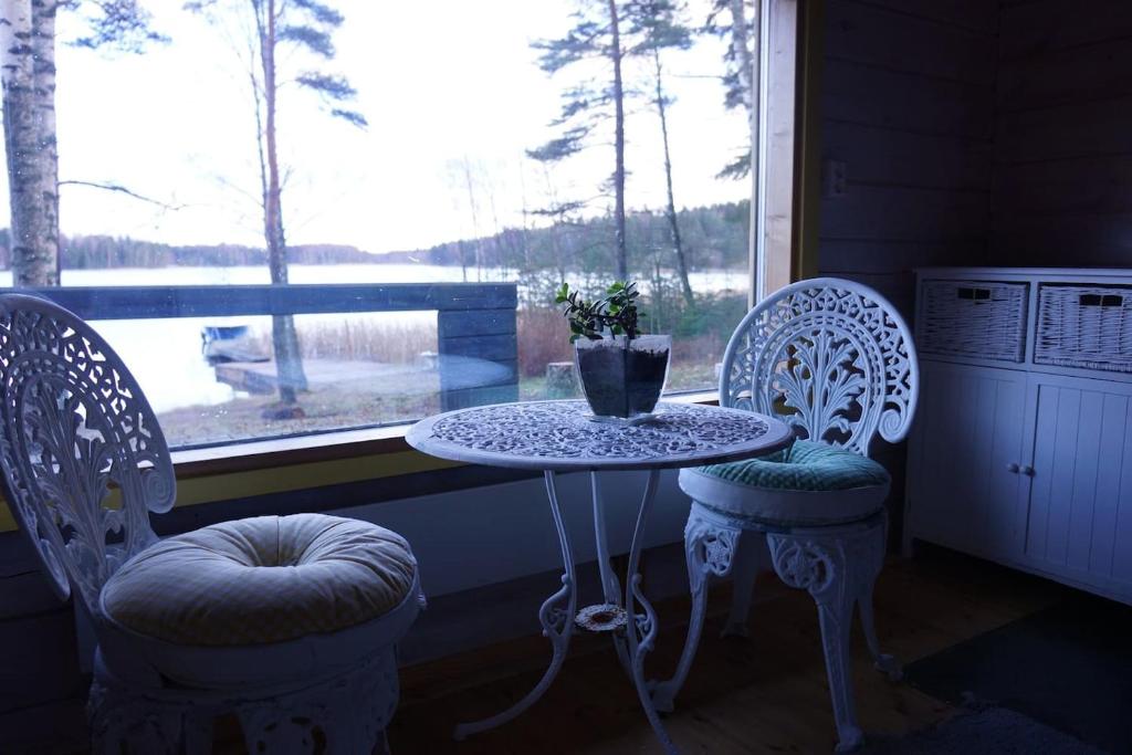 une table et deux chaises devant une fenêtre dans l'établissement Stenstrandintie 20 B, à Jorvas
