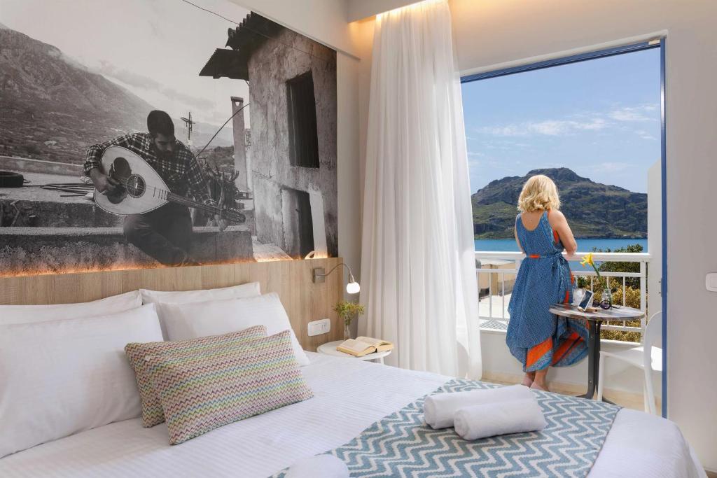une femme debout dans une chambre d'hôtel avec un lit dans l'établissement Sofia Hotel, à Plakias