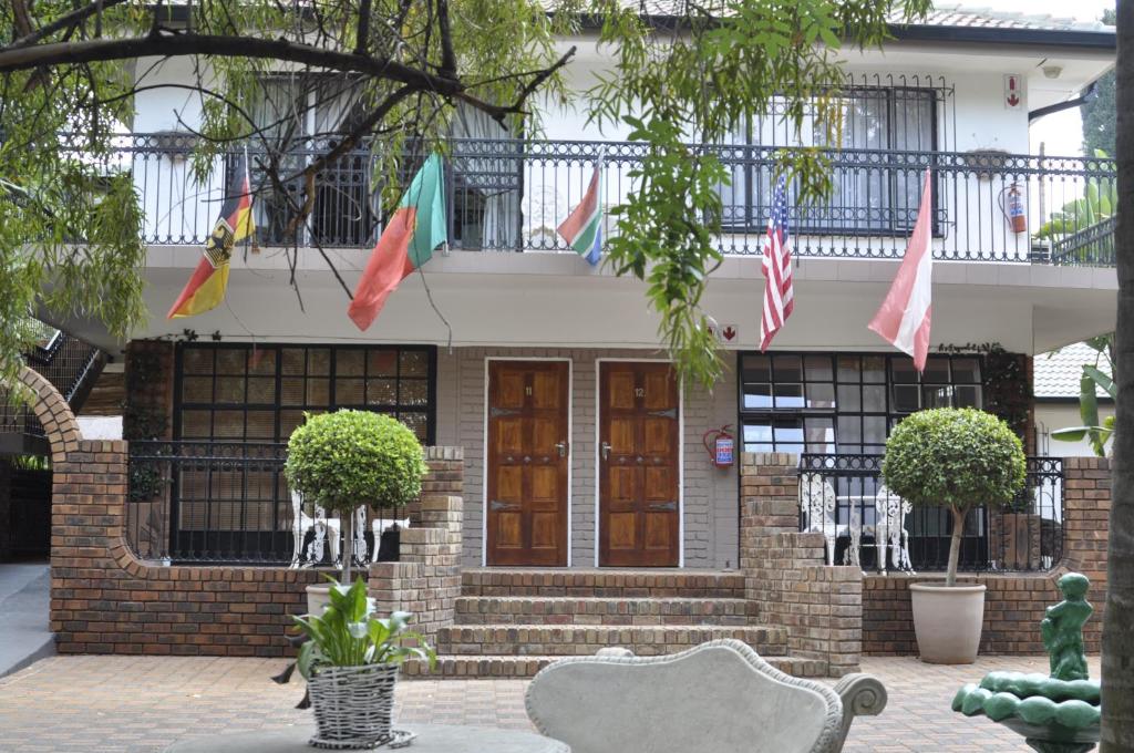 a house with flags on the front of it at A Knights Rest Guesthouse in Pretoria
