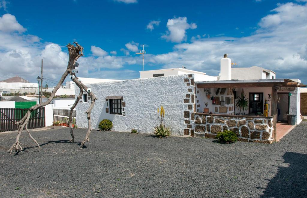 una estatua frente a un edificio blanco en La Cuesta14, en Güime