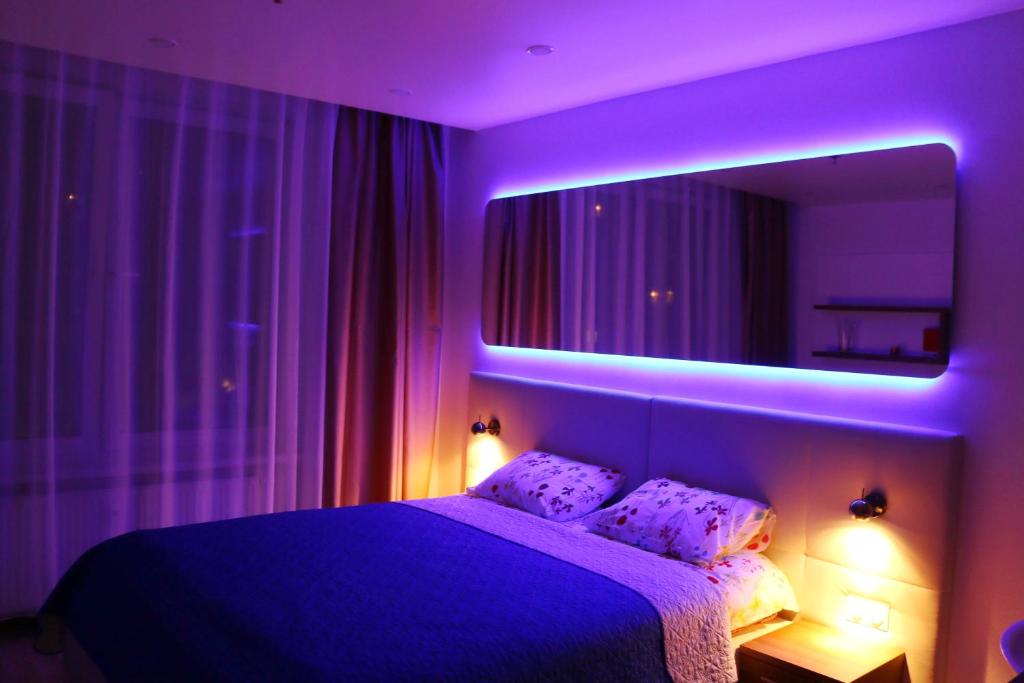 Dormitorio púrpura con cama y espejo en Yes O'K96577триста два пять пять, en San Petersburgo