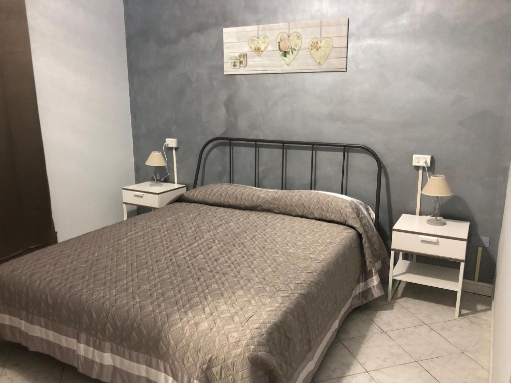 sypialnia z łóżkiem i 2 szafkami nocnymi z lampkami w obiekcie Affittacamere Roma w San Remo
