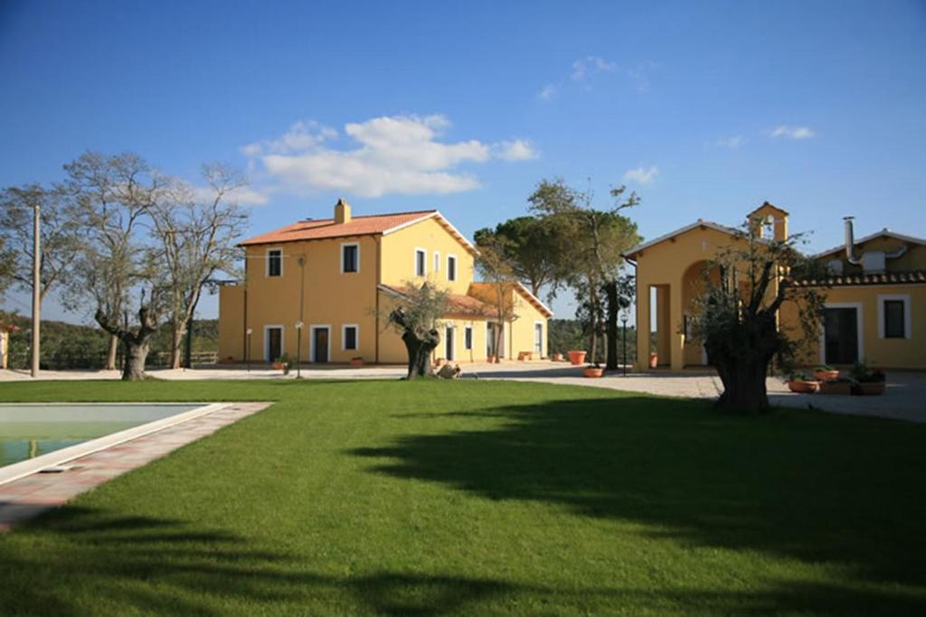 una casa grande con un césped verde delante de ella en Agriturismo Toscanella, en Montebello