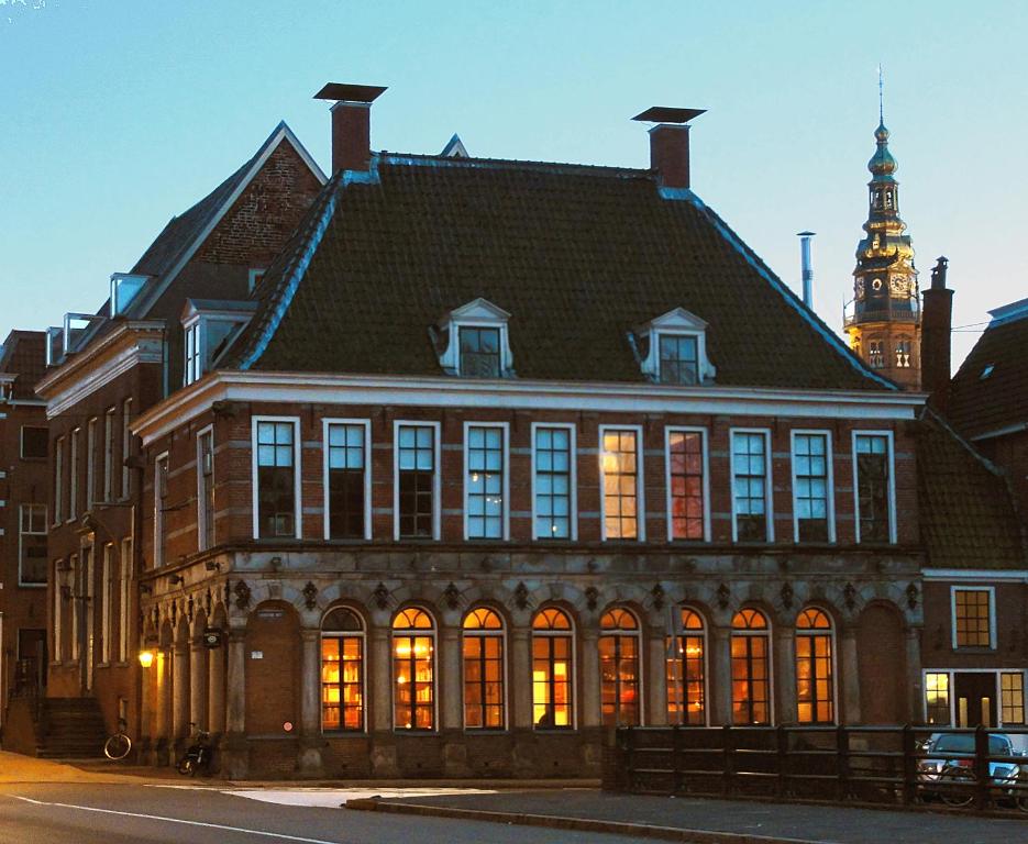 
a large building with a clock on the front of it at Hotel Corps de Garde in Groningen
