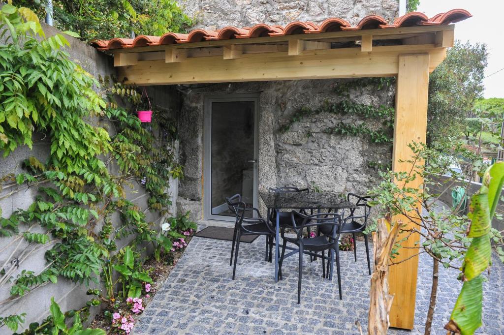 a patio with a table and chairs under a pergola at Casa do Azevinho - Grupo Casas Vale do Lima in Ponte de Lima