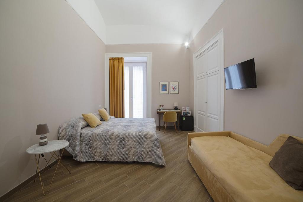 a bedroom with a bed and a couch at B&B Galleria Principe di Napoli in Naples