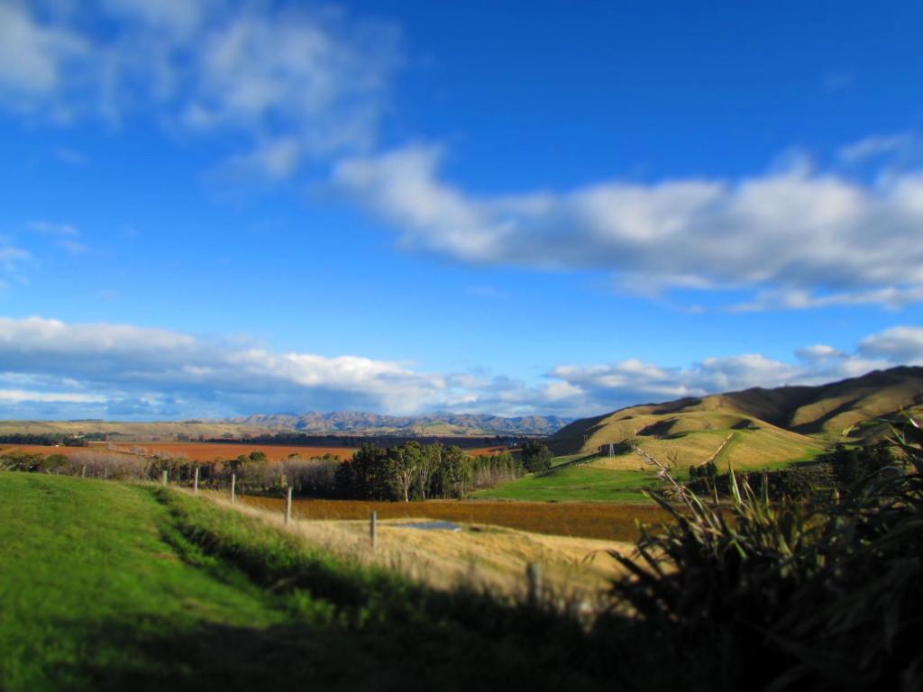 uma vista para um campo com montanhas ao fundo em Hill Top Retreat em Lower Dashwood