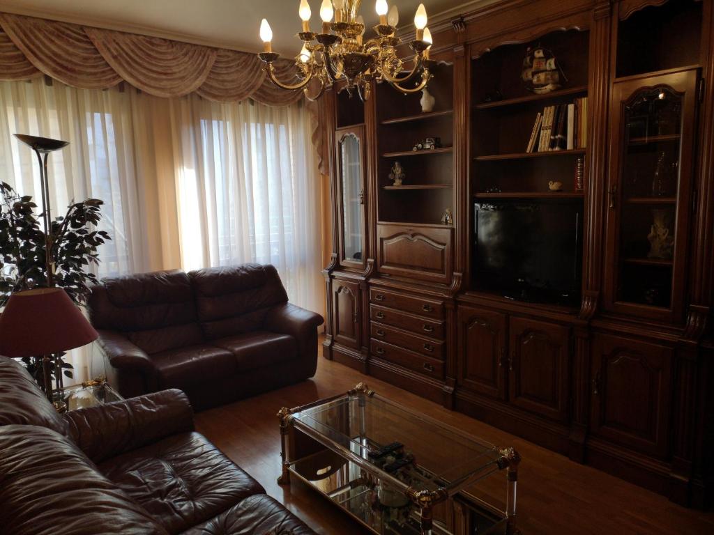 uma sala de estar com um sofá e uma televisão em Apartamento GALLARZA con Parking em Ezcaray