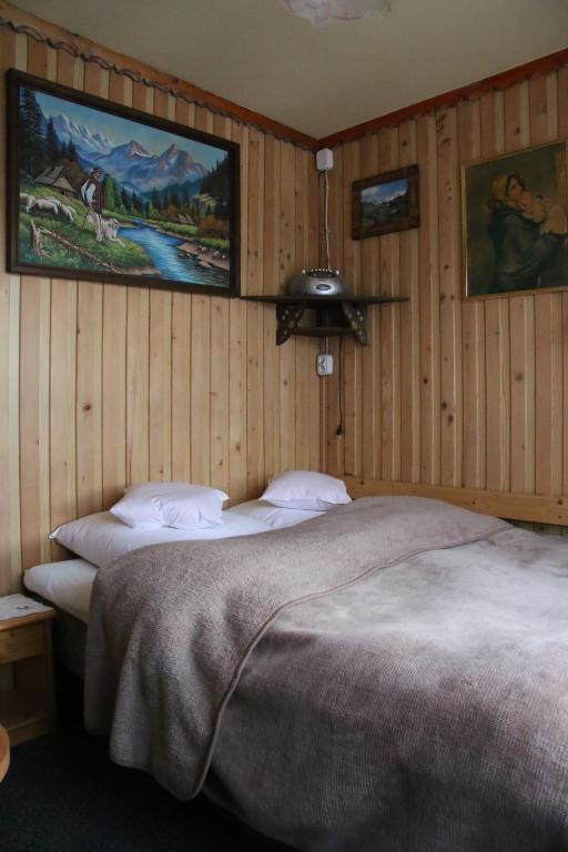 a bedroom with two beds and a painting on the wall at Noclegi Bukowina Centrum in Bukowina Tatrzańska
