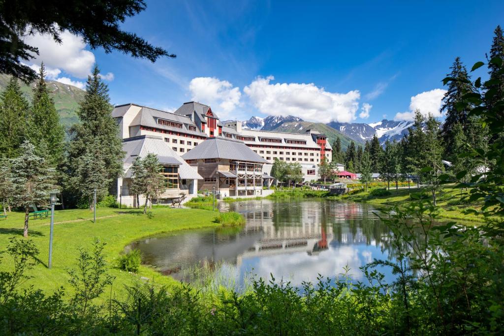 a resort with a river in front of a building at Alyeska Resort in Girdwood