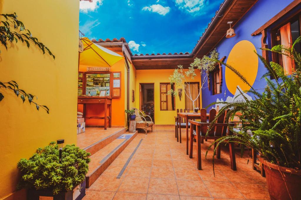 un restaurante con paredes amarillas y azules, mesas y sillas en Hostal El Punto, en La Serena