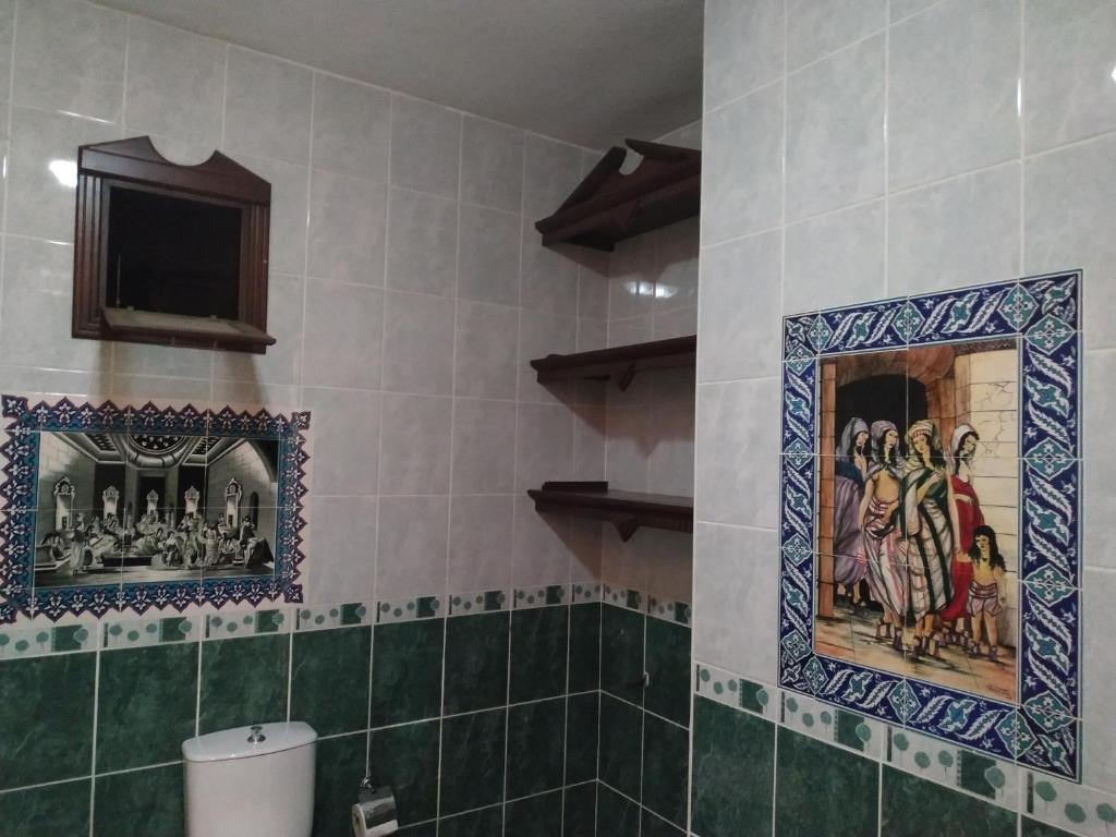 a bathroom with mosaics on the walls and a toilet at EPHESUS CENTRUM in Selcuk