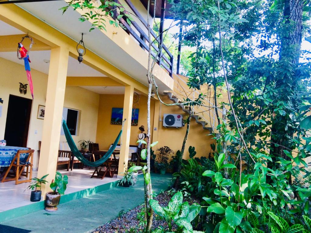 a house with a porch with a hammock in it at Pousada Flor de Gaia in Guarujá