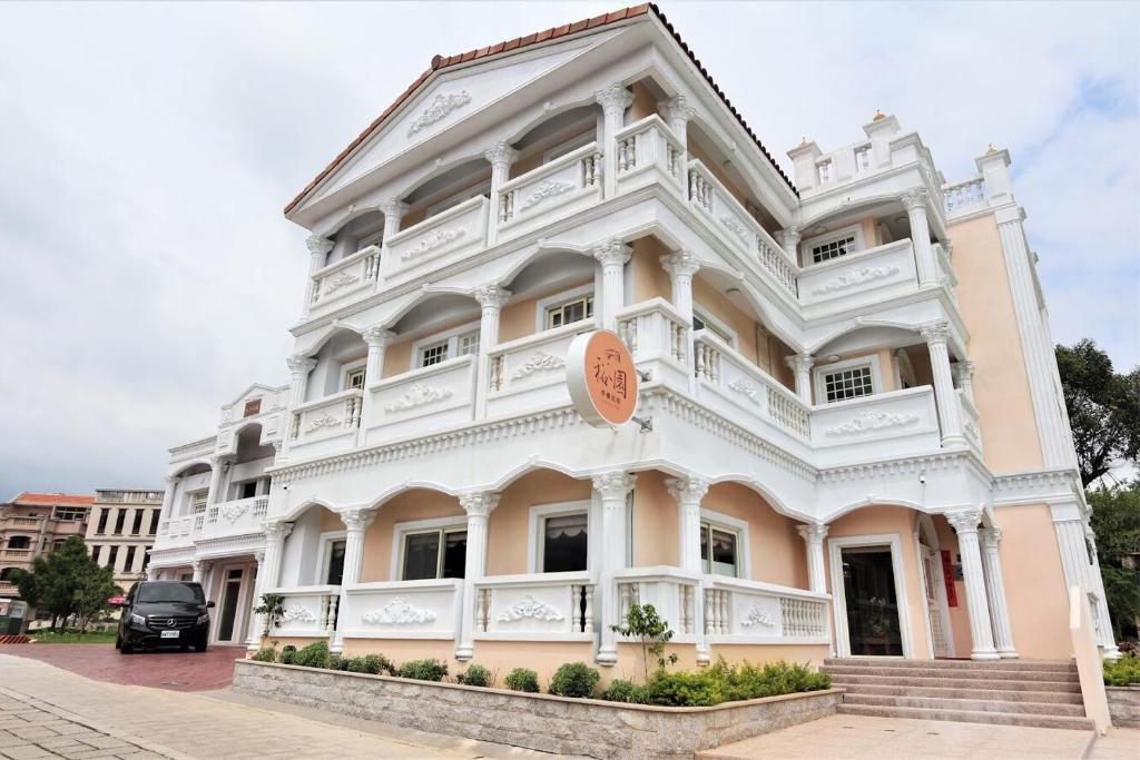 a large white building with a car parked in front of it at Kinmen Yu Yuan in Jincheng