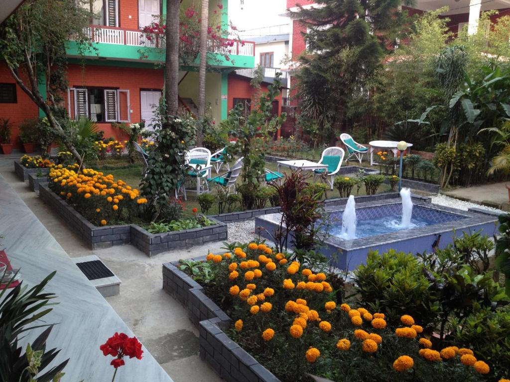 un jardin avec des oranges et des fleurs devant un bâtiment dans l'établissement New Pokhara Lodge - Lakeside, Pokhara Nepal, à Pokhara