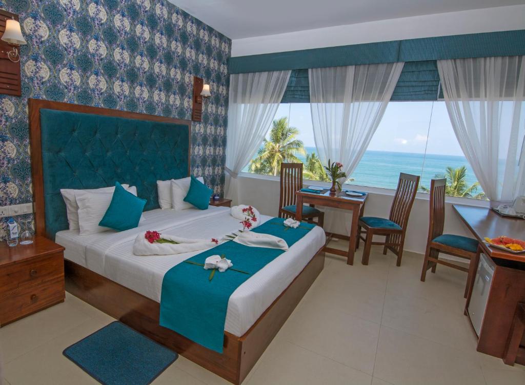 a bedroom with a bed with a view of the ocean at Mount Breeze Hotel in Mount Lavinia