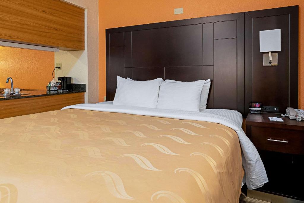 a bedroom with a large bed with a large headboard at Quality Inn & Suites in Robbinsville