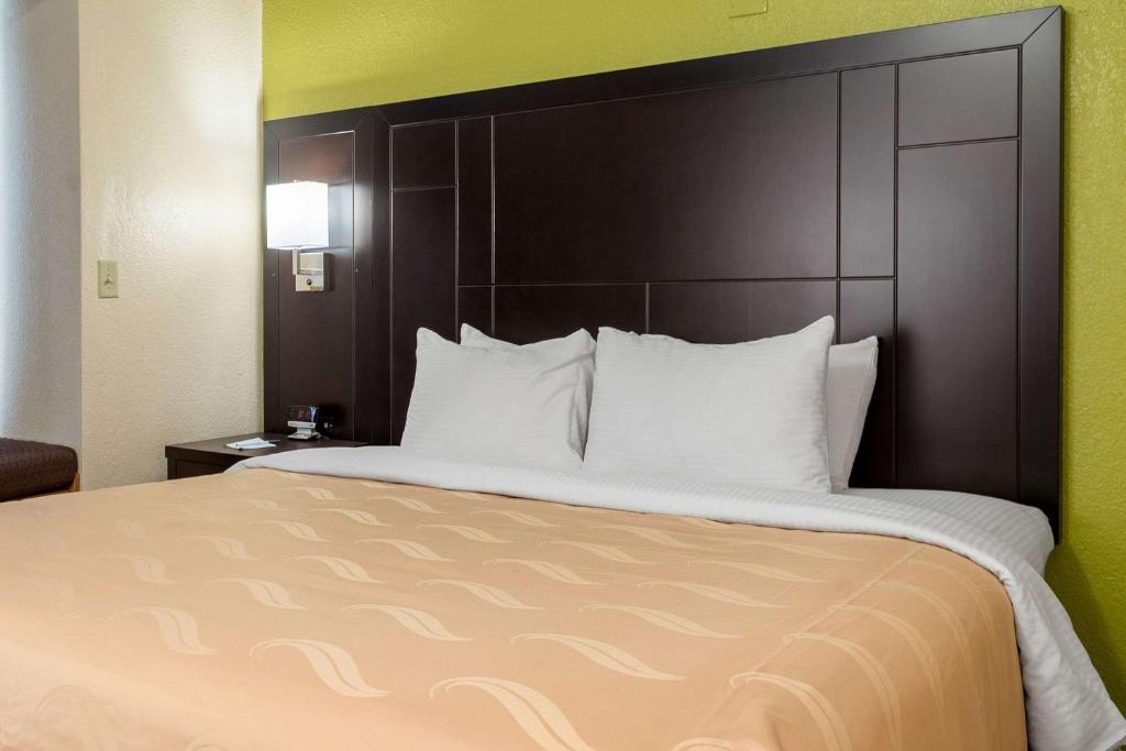 a large bed with a large headboard in a hotel room at Quality Inn & Suites in Robbinsville