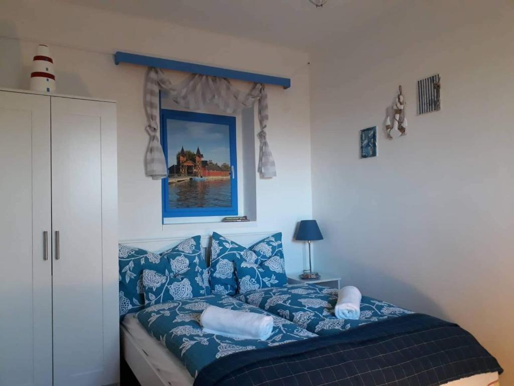 ein Schlafzimmer mit einem blauen Bett mit blauen Kissen in der Unterkunft Clara Apartman in Keszthely
