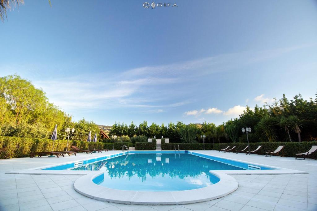 a large swimming pool with chairs and trees at Torre Venza in Valderice