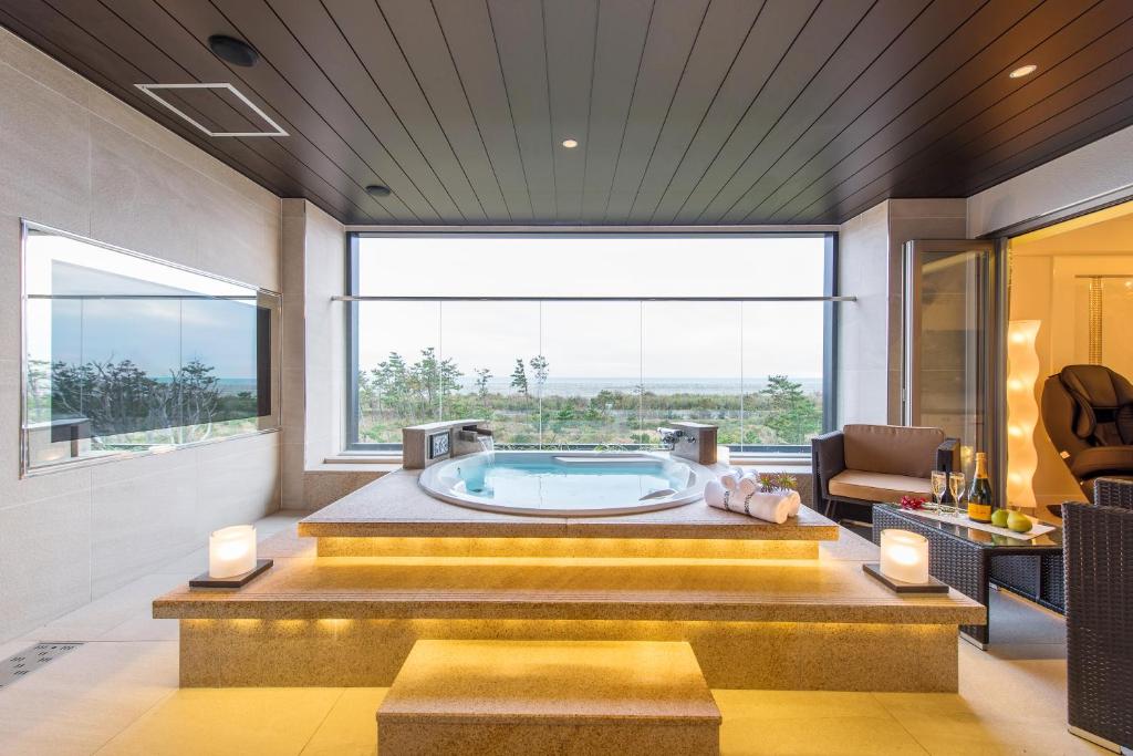 ein großes Bad mit einer Badewanne und einem großen Fenster in der Unterkunft HOTEL Dior7 in Hamamatsu