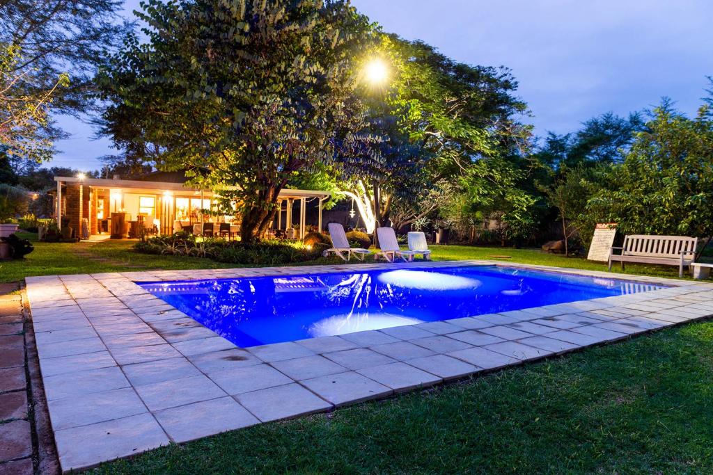 Biweda Nguni Lodge في Mkuze: مسبح في الحديقة الخلفية للمنزل