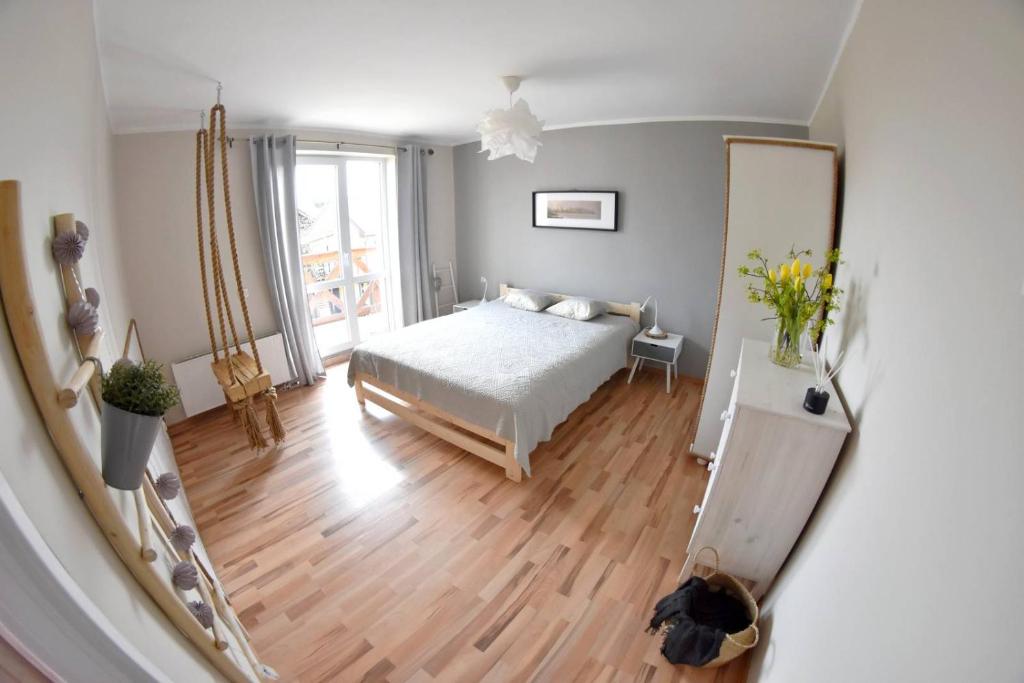 a bedroom with a bed and a mirror at Apartament No. 2 in Łeba