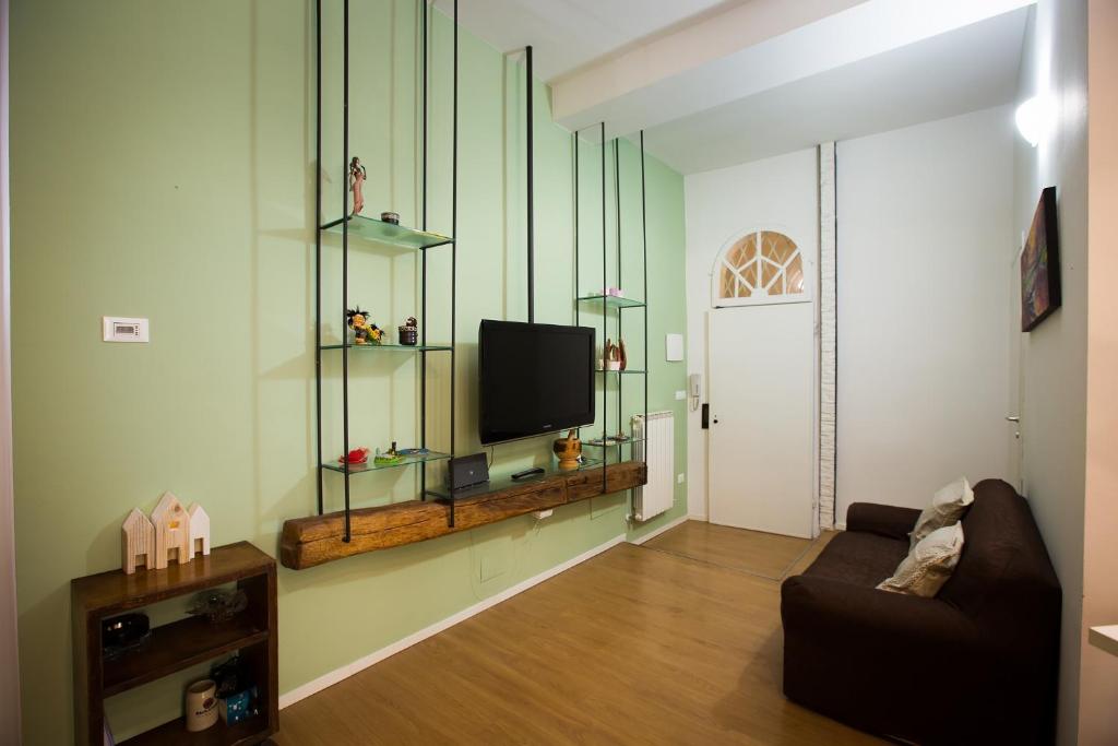 uma sala de estar com um sofá e uma televisão em Guasto Apartment em Bolonha