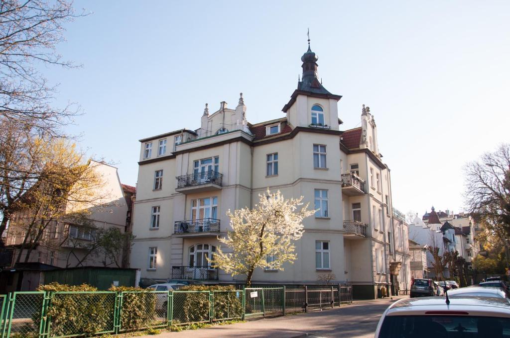 a large white building on the side of a street at Apartament Pod Haffnerem in Sopot