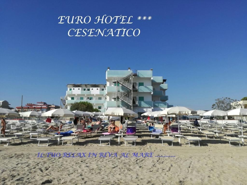 uma praia com cadeiras e guarda-sóis e um hotel em EuroHotel em Cesenatico