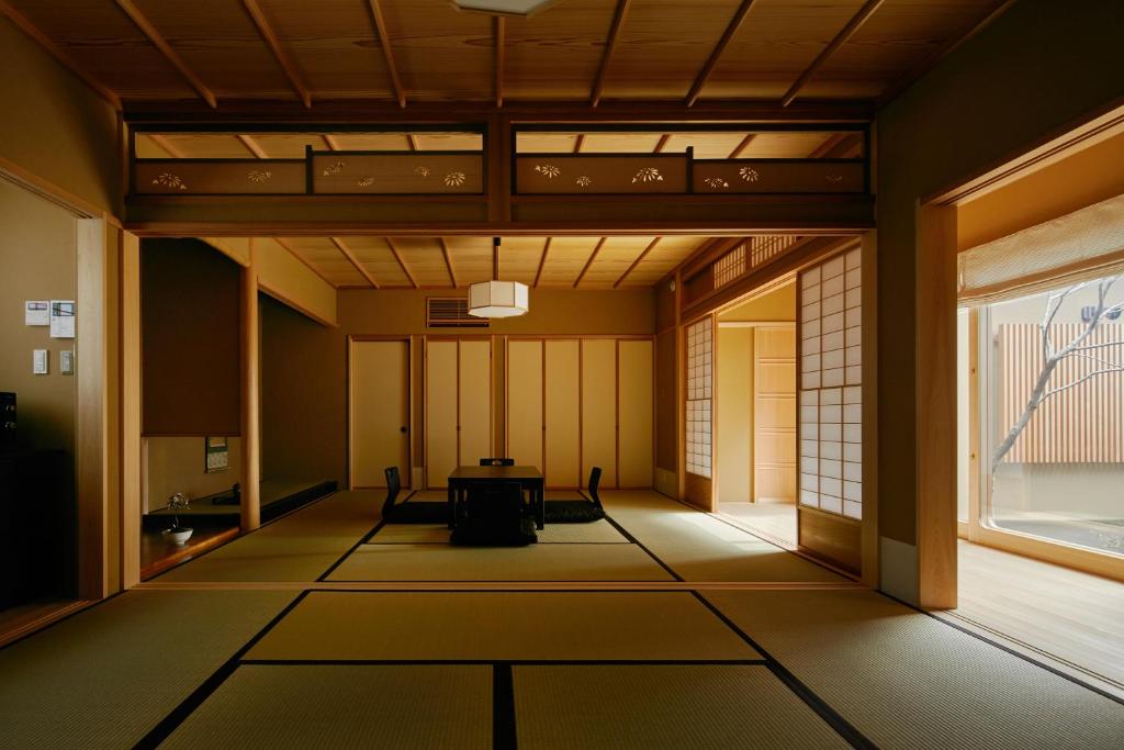 an empty room with a table and a window at HANARE KYOTO Onyado Hasegawa in Kyoto