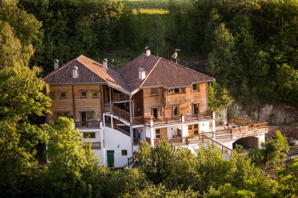 duży drewniany dom na wzgórzu z drzewami w obiekcie Apartments Schlossblick - Wohnung Rosengarten w mieście Vols am Schlern