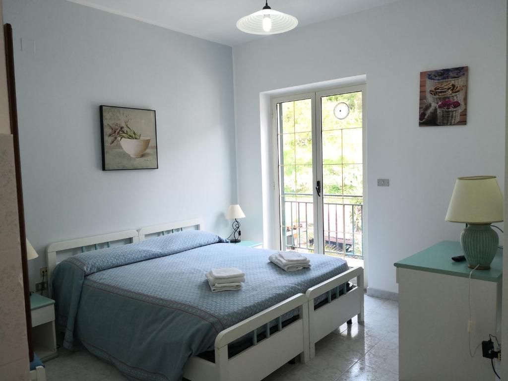 een witte slaapkamer met een bed en een raam bij Palia's Hotel in Laino Borgo