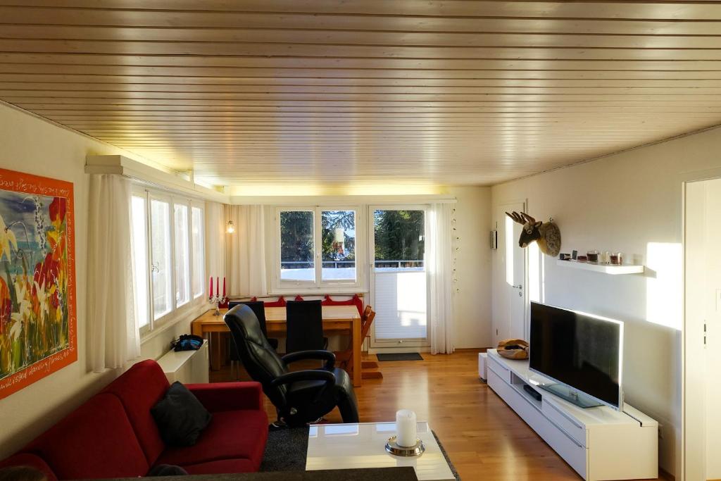uma sala de estar com um sofá vermelho e uma mesa em Chalet Windegg - CharmingStay em Flumserberg