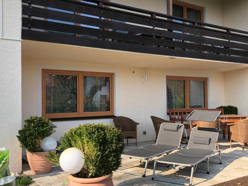 a patio with chairs and a table and a balcony at Zweite Heimat in Übersee